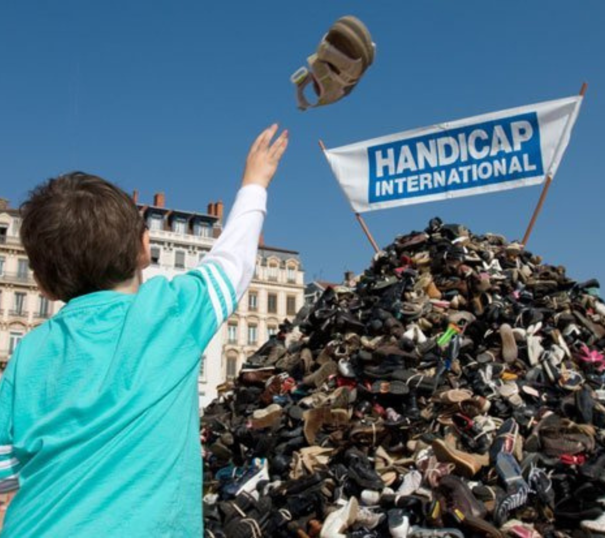 Photo d'un enfant qui lance des chaussures sur la pyramide de chaussure.